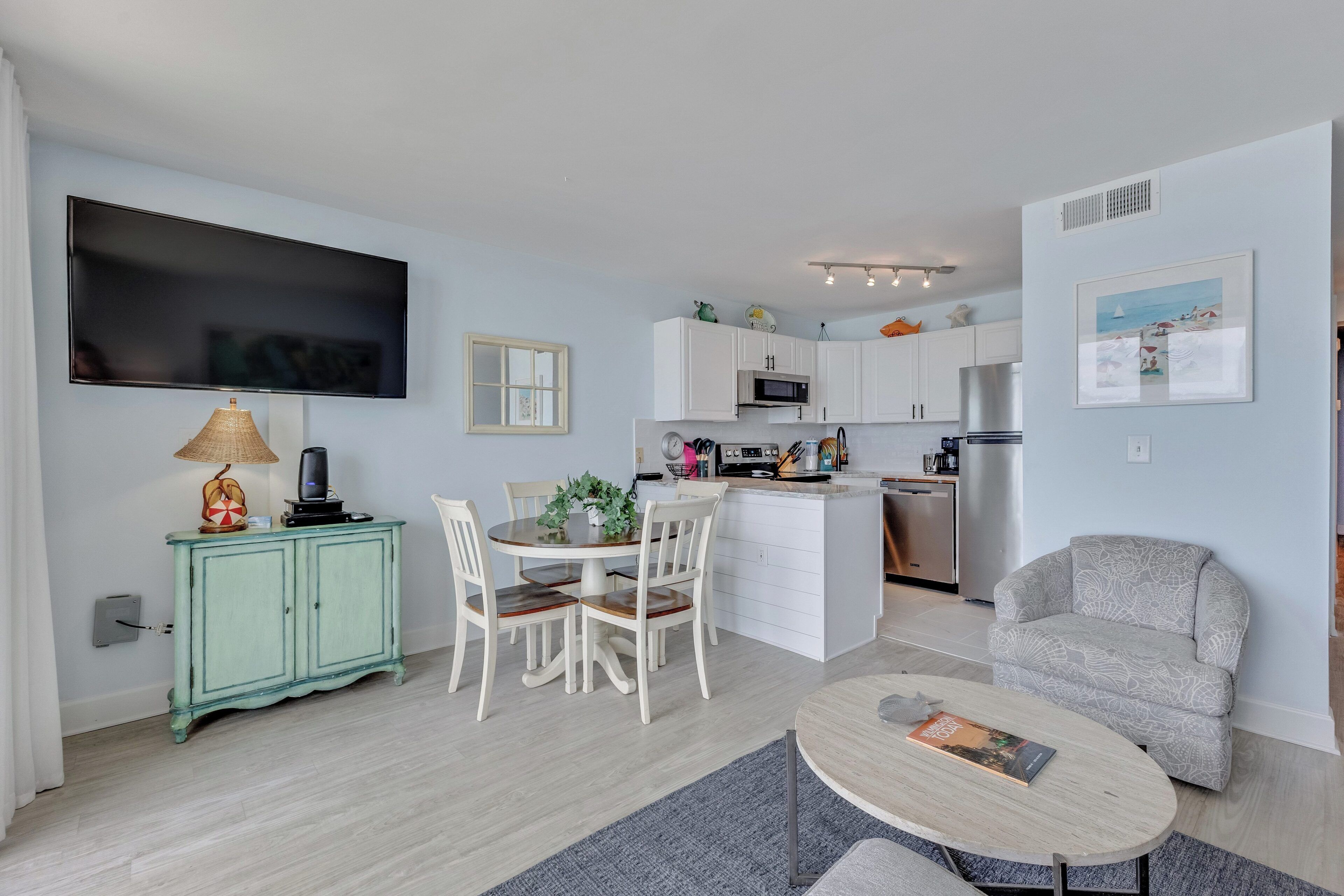 A modern living space with a dining area, kitchen, and seating area.
