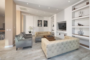 A modern living room with a sofa, armchairs, a coffee table, and a TV. - Luxury villa Natali w pool, terrace and sea view (Podstrana)