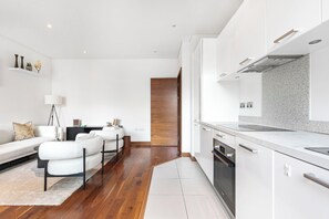 Eine moderne Küche mit weißen Schränken, einem eingebauten Backofen und einer Arbeitsplatte.