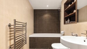 Ein modernes Badezimmer mit Badewanne, Toilette und Waschbecken.