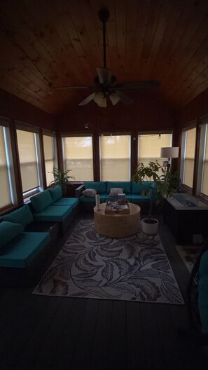 A room with a wooden ceiling, a ceiling fan, a sectional sofa, a coffee table, and a patterned rug. - Clifford Luxury Retreat 3BR Self Check In Home (Northbridge)