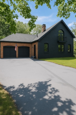 A two-story building with a garage, a balcony, and a flag. - Clifford Luxury Retreat 3BR Self Check In Home (Northbridge)