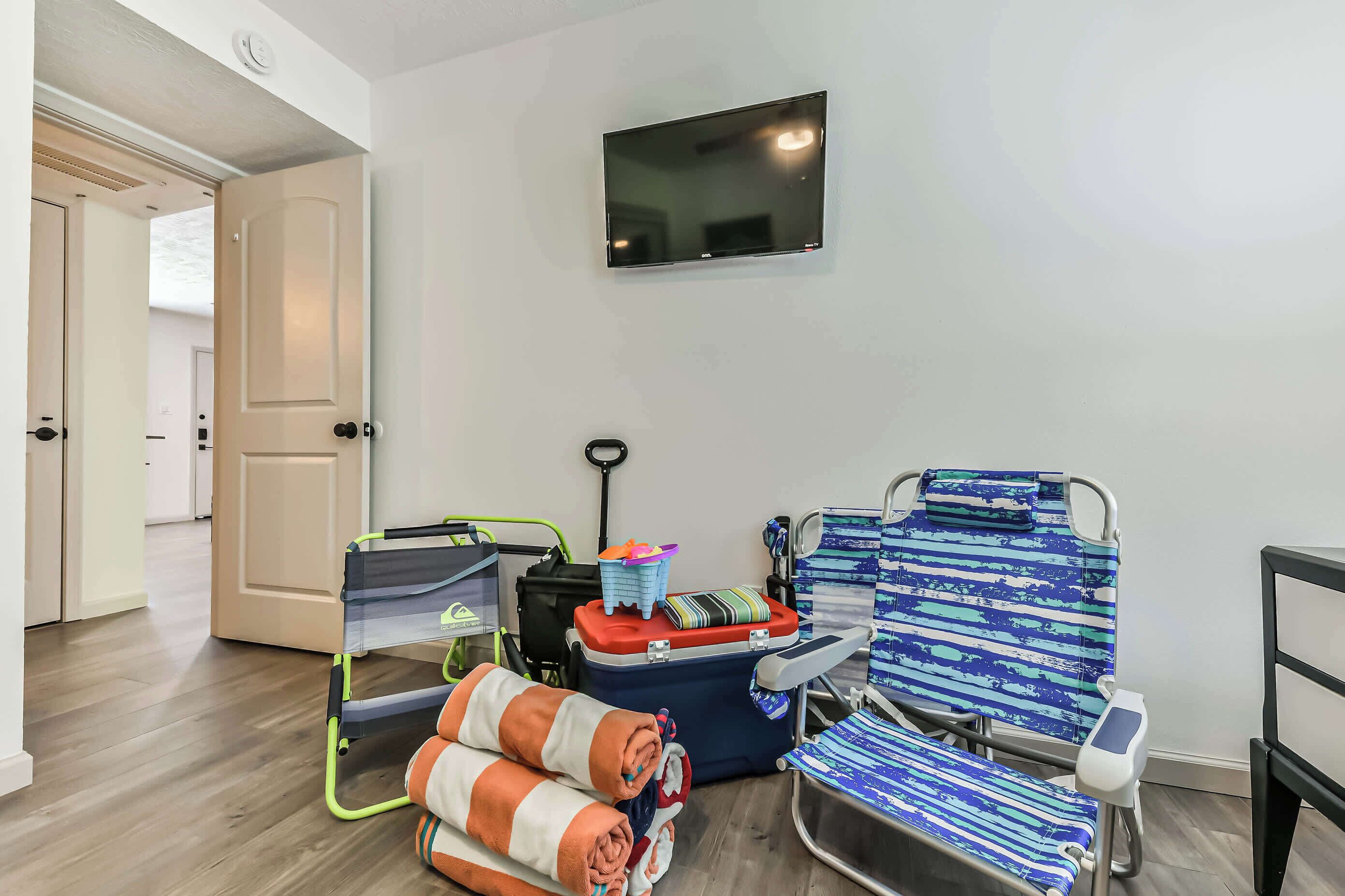 Une chambre avec un lit, un téléviseur, un fauteuil roulant, un déambulateur et une valise.