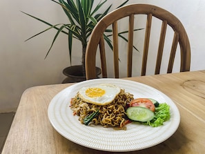 A plate of noodles with egg and vegetables on a white plate.
