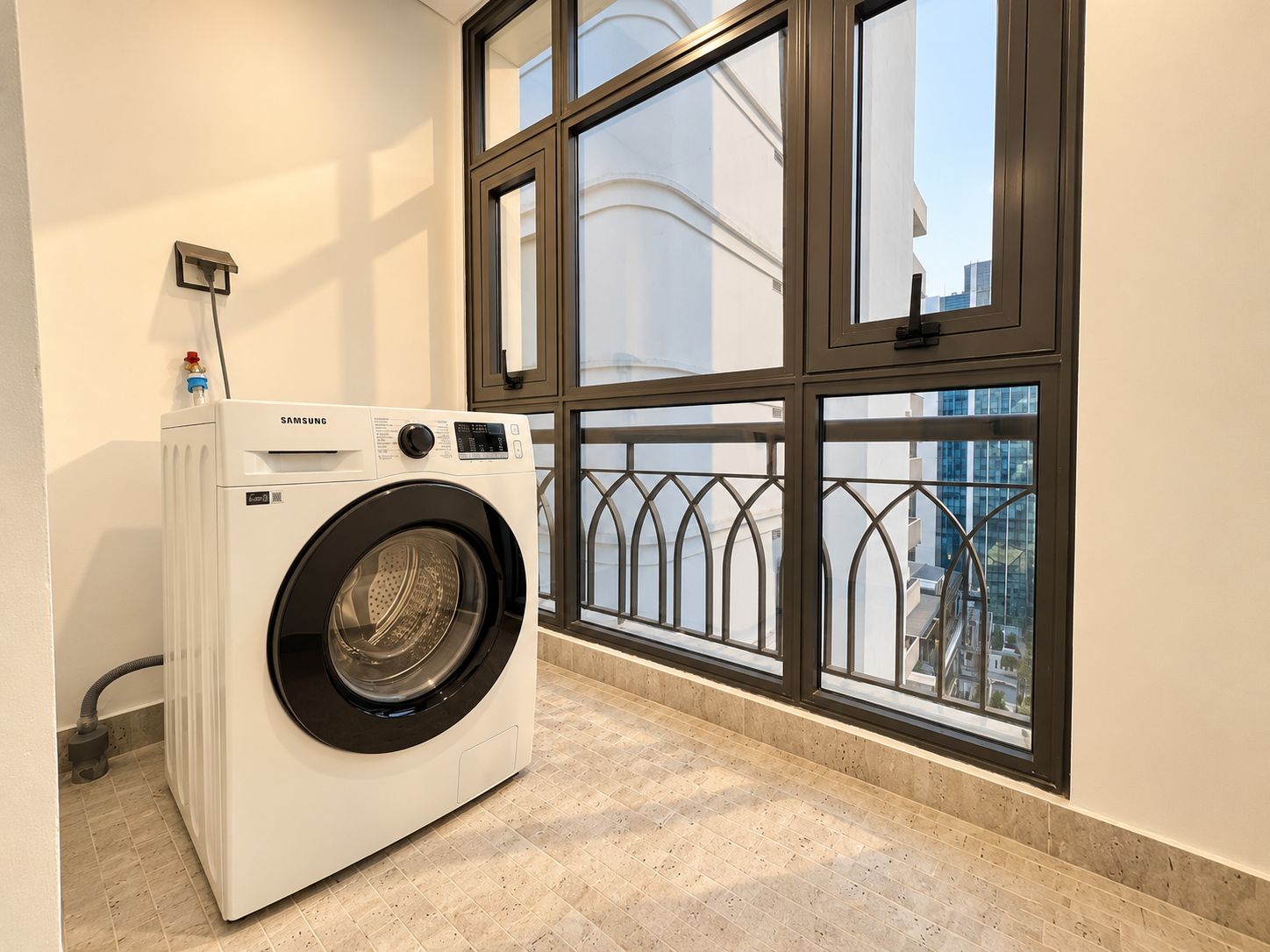 A front-loading Samsung washer in a room with a large window and a view of a building.