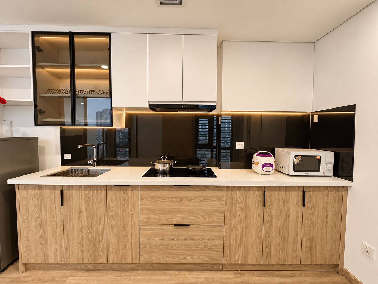 Una cocina moderna con una isla central, electrodomésticos integrados y vistas a la ciudad.