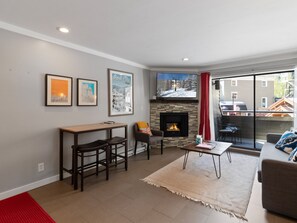 Ein Wohnzimmer mit Kamin, Essbereich und einer Couch.