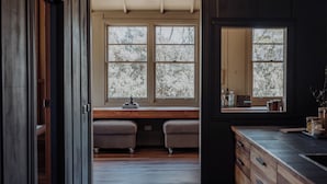 A modern kitchen with wooden cabinets, a large window, and a bench.
