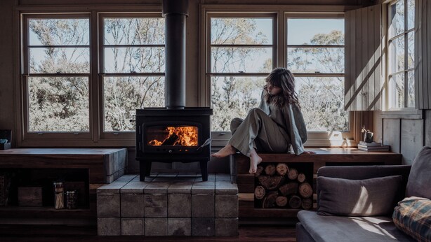 A cozy room with a fireplace, large windows, and a comfortable seating area.