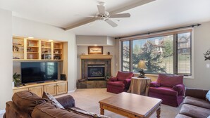A living room with a fireplace, television, and seating area. - Peaceful Retreat, Pool&Hot Tub, Walk to Village, Private Shuttle, Bike Anywhere! (Steamboat Springs)