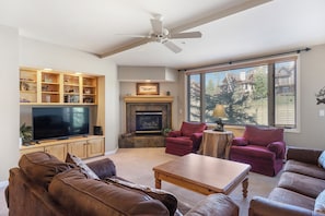A living room with a fireplace, television, and seating area. - Peaceful Retreat, Pool&Hot Tub, Walk to Village, Private Shuttle, Bike Anywhere! (Steamboat Springs)