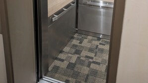 A narrow elevator with metallic walls and a patterned carpet. - Peaceful Retreat, Pool&Hot Tub, Walk to Village, Private Shuttle, Bike Anywhere! (Steamboat Springs)