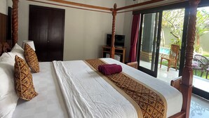Una cama con dosel de estructura de madera, un televisor y vistas al exterior.