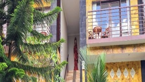 Un edificio de varios pisos con una escalera que lleva a un balcón con mobiliario exterior.