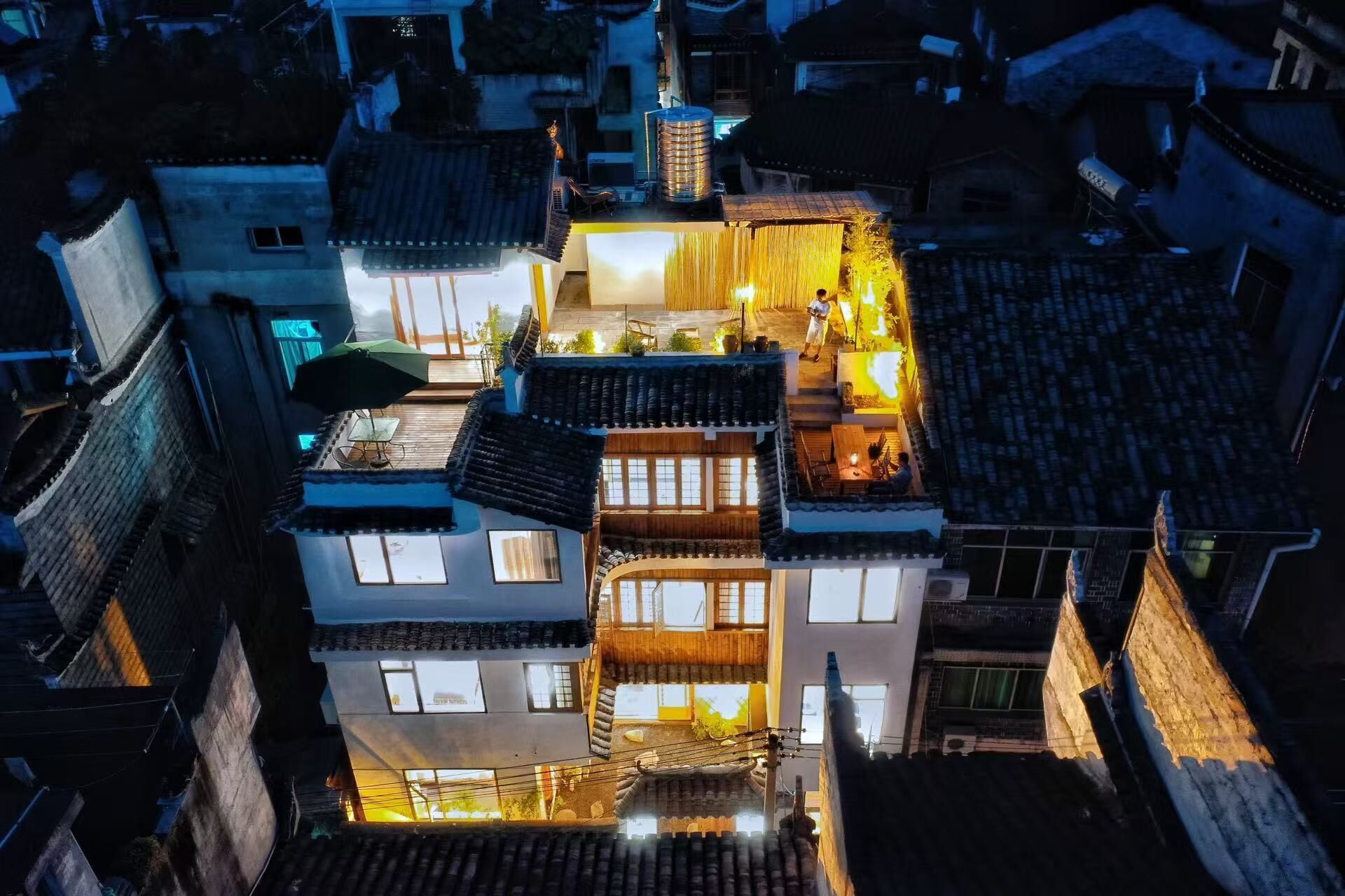A multi-story building with traditional architecture, featuring balconies and a rooftop terrace.