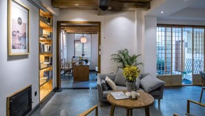 A modern living room with a sofa, a round coffee table, a bookshelf, and a dining area. - Fenghuang Bahaobieyuan (Xiangxi)