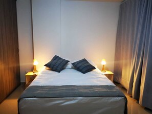 A hotel room with a bed, two bedside lamps, and a curtain. - Family apartment close to the beach in Rodadero Sur (Gaira)