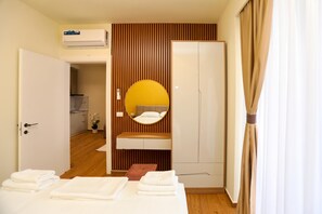 A hotel room with a bed, a bedside table, a mirror, a bathroom, and a kitchenette. - La Dimora Azzurra 902, Vlore, Albania (Vlore)