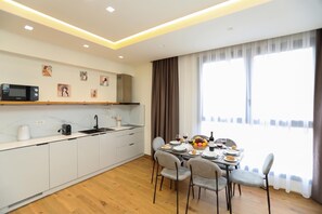 A modern kitchen with a dining area, featuring a microwave, sink, and a table set for dining. - La Dimora Azzurra 903, Vlore, Albania (Vlore)