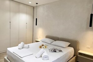 A modern hotel room with a large bed, a bedside table, a wardrobe, and a hanging light fixture. - La Dimora Azzurra 501, Vlore, Albania (Vlore)