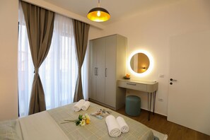 A hotel room with a bed, a desk with a mirror, a wardrobe, and a bedside table. - La Dimora Azzurra, Vlore, Albania (Vlore)