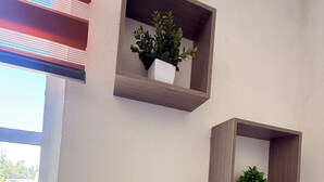 Drei an der Wand befestigte Holzregale mit Blumentöpfen.