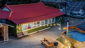 A building with a red roof, a covered patio area, and a solar panel installation. - Yangyang Yellowstop Pet-friendly Pension (Yangyang)