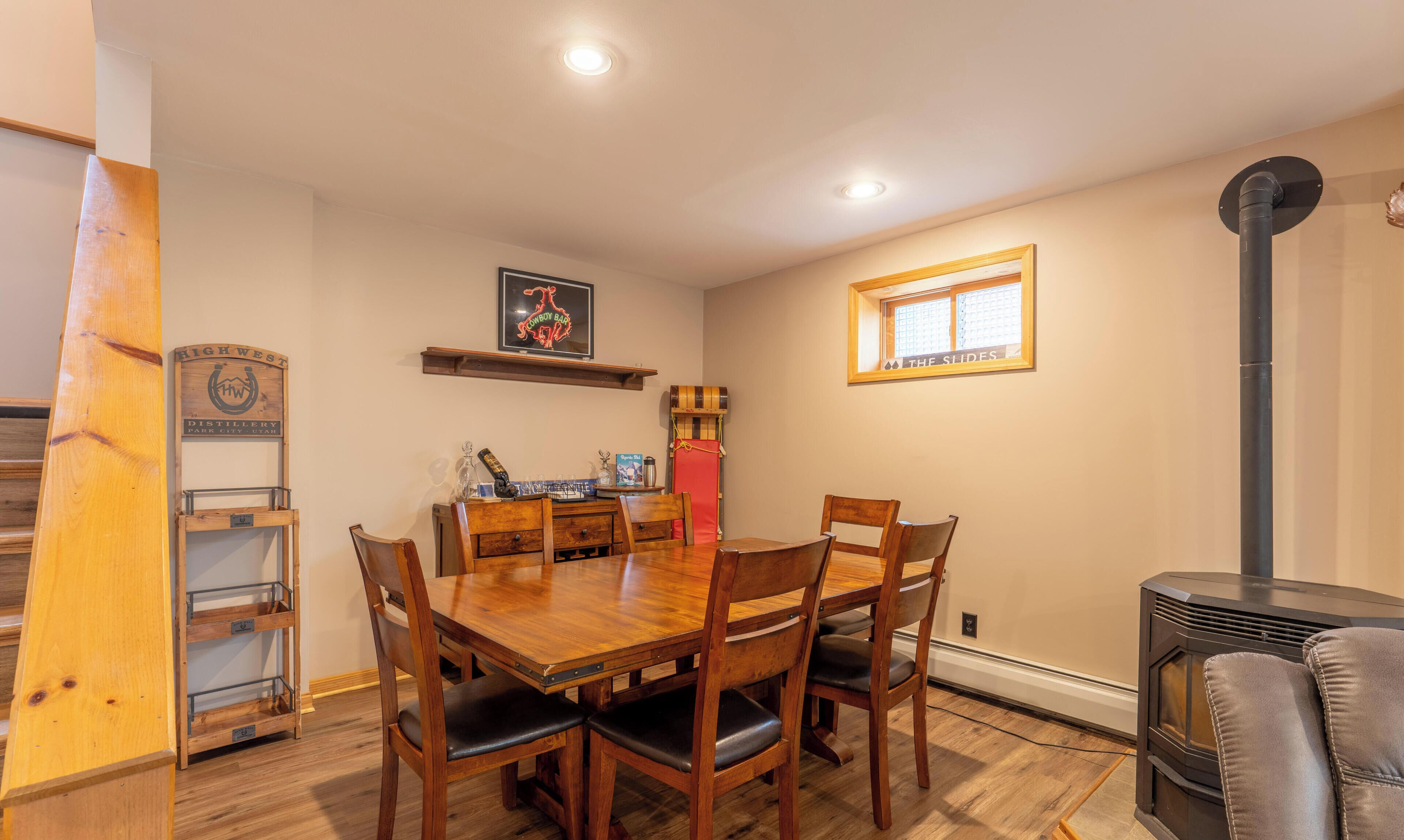 Un coin repas avec une table et des chaises en bois, un tableau accroché au mur, une fenêtre et une cheminée.
