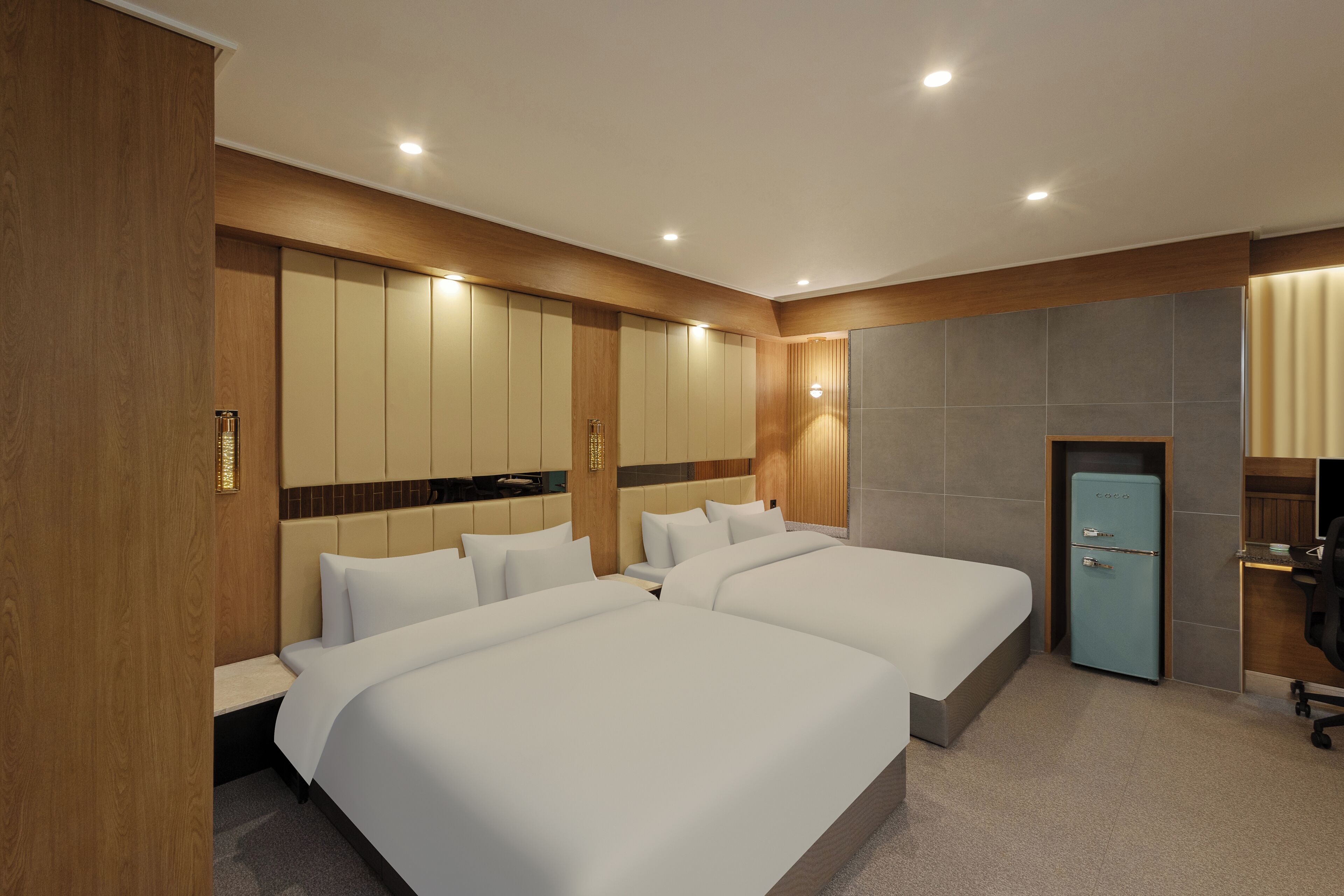 A hotel room with two beds, a desk, and a wardrobe.