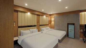 A hotel room with two beds, a desk, and a wardrobe.