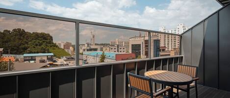 A balcony with a view of a cityscape, including buildings and a church.
