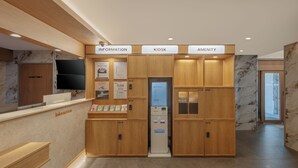 Et receptionsområde med afmærkede sektioner til information, kiosk og faciliteter.