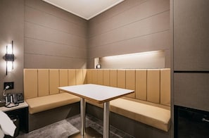 A modern room with a bench, a table, a wall-mounted light, and a phone on a side table. - BROWNDOT HOTEL ANDONG OKDONG (Andong)