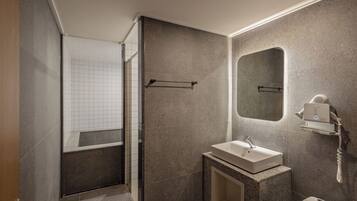 A modern bathroom with a shower, a sink, and a mirror.