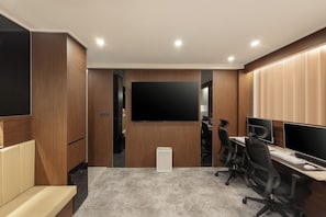 A modern office space with a large flat-screen TV, two desks with computers, office chairs, and a sofa. - BROWNDOT HOTEL ANDONG OKDONG (Andong)