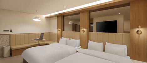 Habitación de hotel con dos camas, zona de estar, televisor de pantalla plana y minibar.