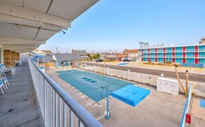 A hotel with a pool area, a covered balcony, and a building with colorful exterior.