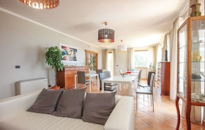 Ein modernes Wohnzimmer mit Sofa, Essbereich und Küche.