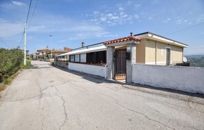 Une rue étroite avec un immeuble doté d’une grande fenêtre et d’une porte.