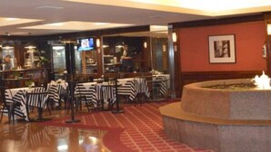 A restaurant with tables and chairs, a bar area, and a fountain. - Studio in the sky: Obelisco - Av Corrientes. Microcentro CABA. Argentina. (Buenos Aires)