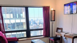 A hotel room with a large window, a bed, a desk, and a chair. - Studio in the sky: Obelisco - Av Corrientes. Microcentro CABA. Argentina. (Buenos Aires)