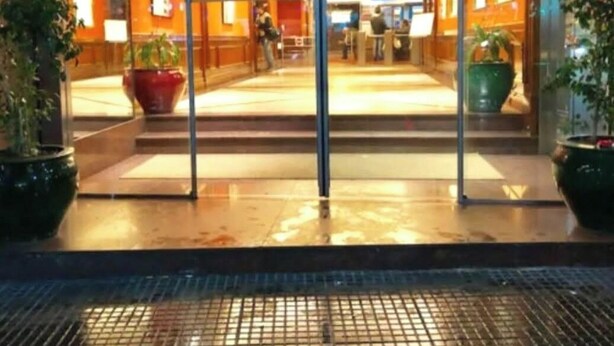 A hotel entrance with a glass door, indoor plants, and a tiled floor. - Studio in the sky: Obelisco - Av Corrientes. Microcentro CABA. Argentina. (Buenos Aires)