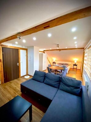 A modern living room with a sofa, a coffee table, and a dining area with a table and chairs. - House by the river  (Plitvica Selo)