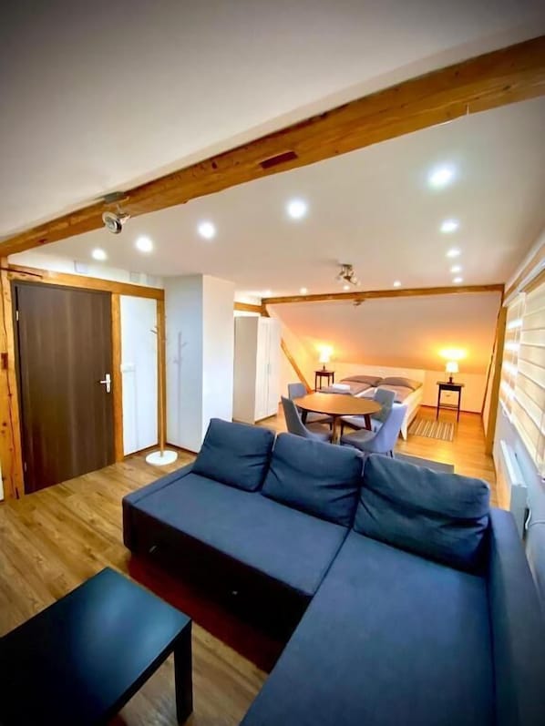 Un salon moderne comprenant un canapé, une table basse et un coin repas avec une table et des chaises.