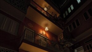 A building with a warm interior lighting, a balcony with a railing, and a door leading to an interior space. - Sheel Mahal Near Hawa Mahal (Jaipur)