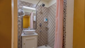 A bathroom with a sink, mirror, shower, and patterned walls. - Sheel Mahal Near Hawa Mahal (Jaipur)