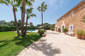 A stone building with a pool and palm trees. - CAN PUIG - Lovely house with private pool and free Wi-Fi (Santanyí)