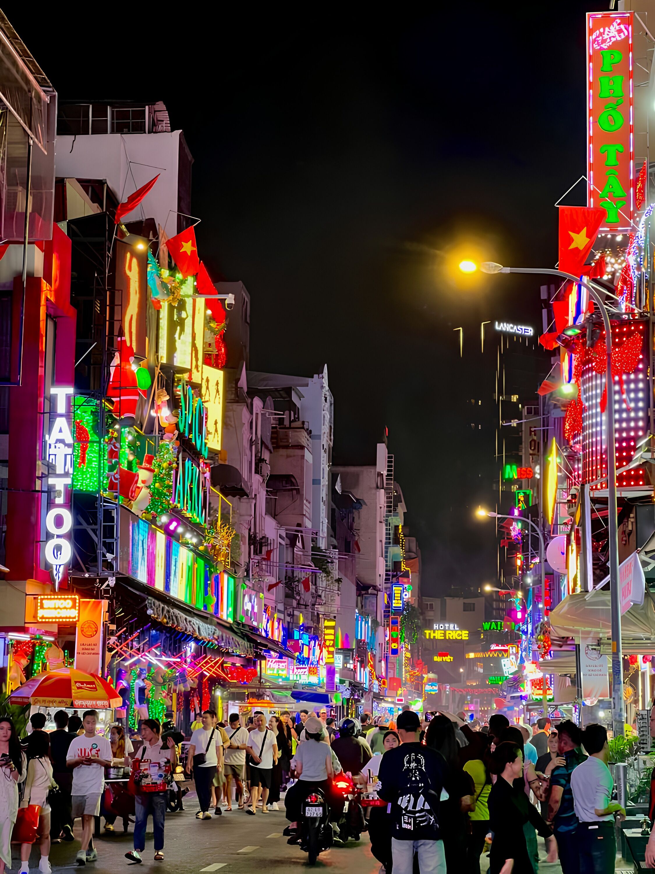 A busy street at night with illuminated signs and buildings.