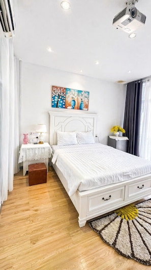 A bedroom with a bed, bedside table, lamp, and a painting on the wall. - Movida Stay - Bui Vien Walking Street, District 1 (Thanh Pho Ho Chi Minh)