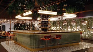 A bar area with a curved counter, hanging lights, and a patterned floor. - Movida Stay - Bui Vien Walking Street, District 1 (Ho Chi Minh City)
